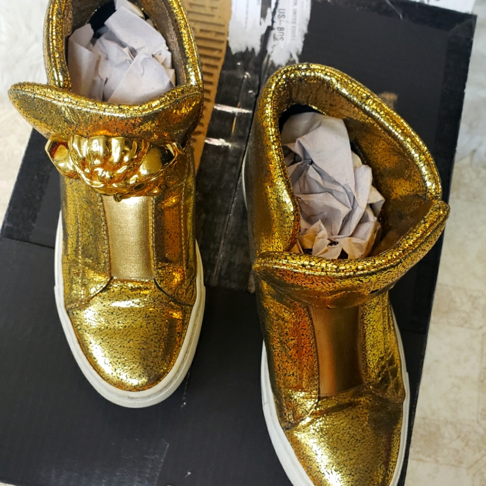The metallic gold Versace sneakers is like new .